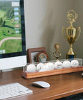 Crystal Clear UV Protected Golf Ball Display Case For Six Balls on wooden desktop with computer, trophies, and cap