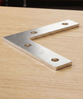 100 Piece L Shaped Corner Bracket Set For Wood Furniture And Frames, Heavy Duty Iron Joining Repair Plates, Silver Finish on Table