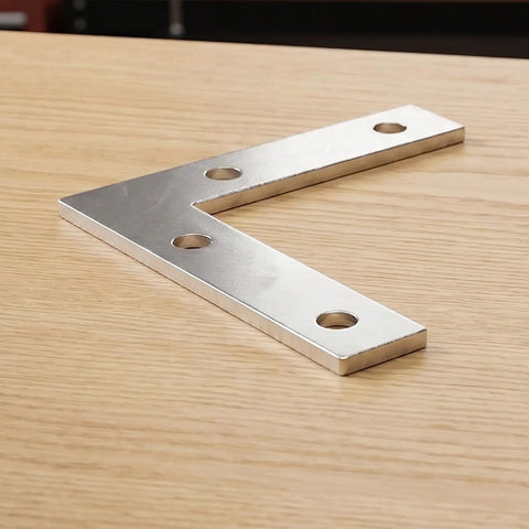 100 Piece L Shaped Corner Bracket Set For Wood Furniture And Frames, Heavy Duty Iron Joining Repair Plates, Silver Finish on Table