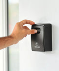 Hand adjusting 4-digit combination on XXL Wall Mount Key Lock Box Outdoor Key Safe Waterproof Heavy Duty Metal Body for secure access.