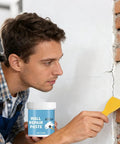 Man applying Hydrophobic Wall Putty For Quick Crack Repair And Easy Go To Application Durable Drywall Filling Compound with spatula