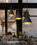 Sunrise Inspired Modern Pendant Lights Set Of 2 Black And Orange Gold Metal Hanging Fixtures For Kitchen Island With Sanded Texture Finish Industrial Urban Style AD 2151 1P2 illuminating a workspace.