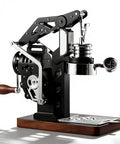Level Up Your Coffee Game With This Dope Hand Cranked Espresso Machine Featuring Pro Grade 58mm Brewing Head And Adjustable Pressure Extraction For Silky Lattes And Cappuccinos At Home Or On The Road. Close-up of black stainless steel espresso machine with wooden handle and pressure gauge.