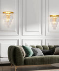 Gold Crystal Wall Sconce Lighting Fixture With Four Tier K9 Crystals in living room above green sofa.