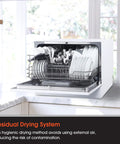 Open Real Deal Compact Countertop Dishwasher For Modern Kitchens showing clean plates and utensils stored for drying.