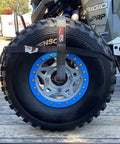 Ultimate UTV Tie Down Kit For Trailer Transport With Tire Bonnets securing a large off-road tire on a trailer.