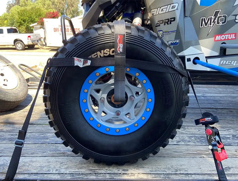 Ultimate UTV Tie Down Kit For Trailer Transport With Tire Bonnets securing a large off-road tire on a trailer.