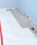 No Nonsense Foam Underlayment Roll Quiet Room Padding For Laminate And Engineered Wood Flooring Radiant Heat Ready laying over white subfloor.