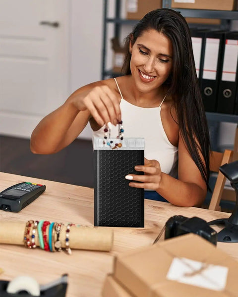 Woman packing jewelry in Black 100 Pack Padded Bubble Mailers 6x10 Inches Self Seal Envelopes for Shipping and Packing