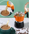 One Cup Stovetop Espresso Pot 150ml 5oz Glass Top Italian Coffee Maker For Italian And Cuban Café Brewing Travel Friendly Compact Design In Orange And Black with brewed coffee pouring into a cup