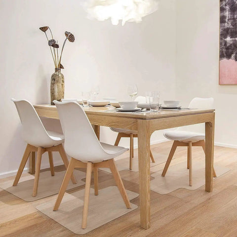 Dining room with white chairs, wooden table set on hardwood floor with chair mats protecting the surface.