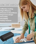 Super Lightweight Cordless Electric Scissors With 4V Battery And LED Light being used to cut fabric on a crafting table.