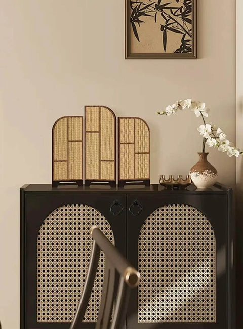 Black cabinet with rattan design, decorative room dividers, and vase with white flowers