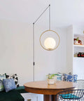 Plug In Globe Pendant Light Fixture With White Glass Ball And Brushed Brass Ring in modern kitchen setting