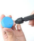 Pro Grade 61 Piece Pin Vise Drill Set with 50 Micro Twist Bits in use on a blue plastic cap for precise small drilling.