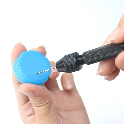 Pro Grade 61 Piece Pin Vise Drill Set with 50 Micro Twist Bits in use on a blue plastic cap for precise small drilling.