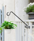 Heavy Duty Deck Hook Railing Bird Feeder Hanger With Rustproof Coating For Flower Baskets And Outdoor Patio Decor Built Like A Tank With Zero Drill Install Holds Twenty Two Pounds No Sweat Setup holding a plant on a railing.