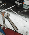 Heavy Duty T Shaped Socket Wrench 10Mm Hex Bit Driver on a workbench with other tools in a garage setting.