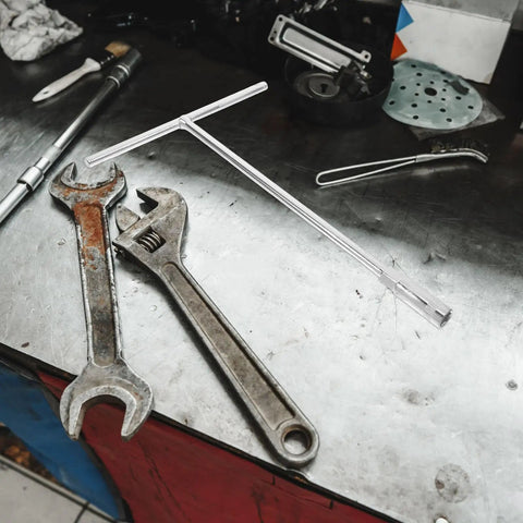 Heavy Duty T Shaped Socket Wrench 10Mm Hex Bit Driver on a workbench with other tools in a garage setting.