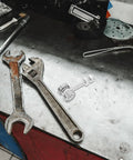 Heavy Duty Stainless Steel V Groove Sliding Door Pulley Wheel Featuring Dual Ball Bearings on a workbench with tools.