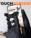 Thick 8 Mil Black Nitrile Gloves Heavy Duty Disposable Work Gear With Serious Diamond Grip Touchscreen Ready being used on a smartphone.