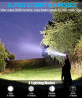 Person using Ultra Bright Tactical Flashlight With Zoomable Beam And Five Lighting Modes in a field at night, illuminating trees.