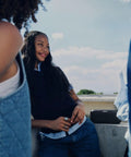 Group of friends enjoying outdoors with SoundLink Plus Portable Bluetooth Speaker For Outdoors With Waterproof And Dustproof Build Plus Up To 20 Hours Battery Life And Boomin Bass For Beach Hangouts Grilling Sessions And Road Trips Black on a ledge.