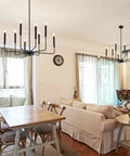 8-Light Modern Black Farmhouse Chandelier With Industrial Metal Arms And Candle-Style Cups in a cozy dining room setting.