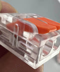 Close-up of a clear plastic and orange 75 Piece Lever Wire Connector Kit For DIY Electrical Projects with push-in terminal.