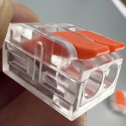 Close-up of a clear plastic and orange 75 Piece Lever Wire Connector Kit For DIY Electrical Projects with push-in terminal.