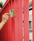 Hand using Six Inch Deck Stain Brush With Wooden Handle For Wide Surface Staining On Decks Fences And Furniture, Extends With Poles