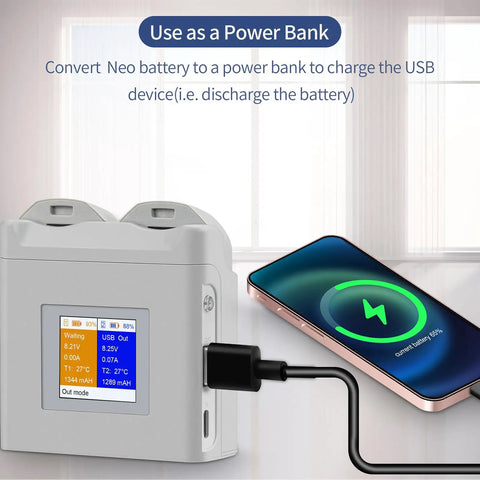 Portable Dual Bay Drone Battery Charger With Color Screen Display charging a smartphone via USB port in a room setting