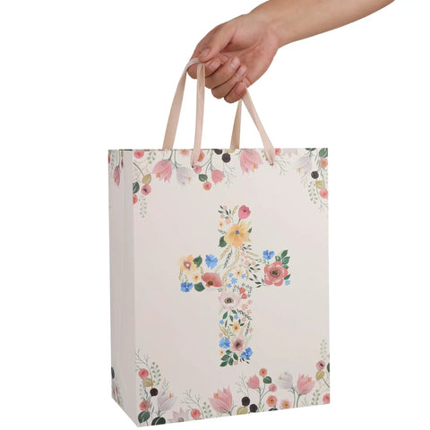 13 Inch Large Light Yellow Floral Gift Bag Set With Greeting Card And Tissue Paper For First Communions Baby Girl Baptisms Christenings And Religious Occasions One Piece, showing floral cross motif held by hand