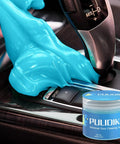 Premium Car Cleaning Gel And Detailing Slime Putty on gear shift, cleaning dirt in tight spaces, blue gel with jar in background.
