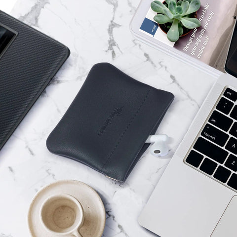 Smooth Vintage Black Leather Squeeze Coin Purse With Heavy Duty Spring Frame, Super Compact Change Holder And Cash Pocket For Hassle Free Everyday Carry By Men And Women on marble surface.