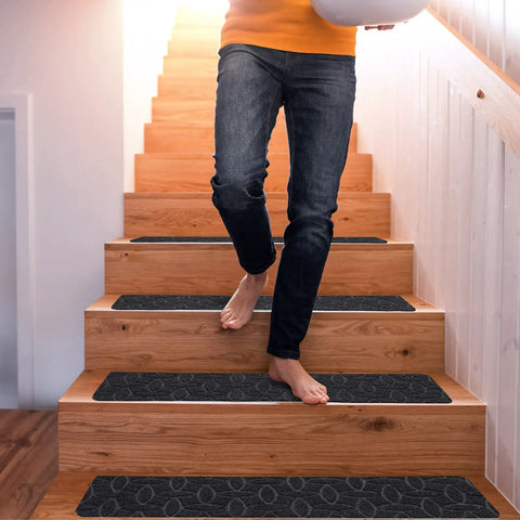 Person walking down stairs with 15 Piece Indoor Stair Treads For Wooden Steps Grippy Non Slip Carpet Treads With Gray Stripe Design Polyester Runner Mats