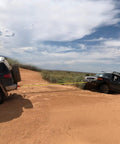 Two trucks using Shackle Hitch Receiver 2 Inch Beefed Up Heavy Duty Recovery Kit With Three Quarter Inch D Ring in off-road towing.