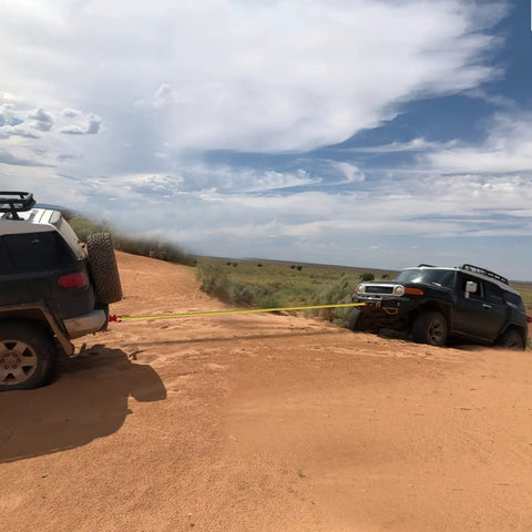 Two trucks using Shackle Hitch Receiver 2 Inch Beefed Up Heavy Duty Recovery Kit With Three Quarter Inch D Ring in off-road towing.