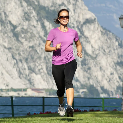 Woman jogging with glasses secured by 10 Pack Glasses Straps Adjustable Eyewear Holder Around Neck Lanyard in a scenic outdoor setting.