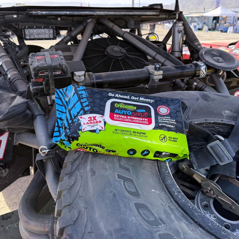AutoSCRUB Cleaning Wipes Heavy Duty 60 Count Cleaning Cloths 15 By 10 Inches on a vehicle tire with engine in background