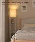 Solid Wood Shelf Floor Lamp With 2 Charging Ports And 1 Power Outlet in a bedroom corner, white finish, beech wood shelves.