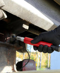 Person using a red Grease Fitting Cleaner Tool Kit Hydraulic Powered Zerk Buster And Rejuvenator for clearing clogged bearings.