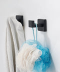 Hefty Matte Black Wall Mount Coat Hook Set Stainless Steel Solid Grip Rack with towel and loofah in bathroom.