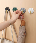 Sleek Adhesive Wall Hooks 4 Pack With Super Tough Grip Tape For Catching Jackets Bags And Keys mounted on wall.