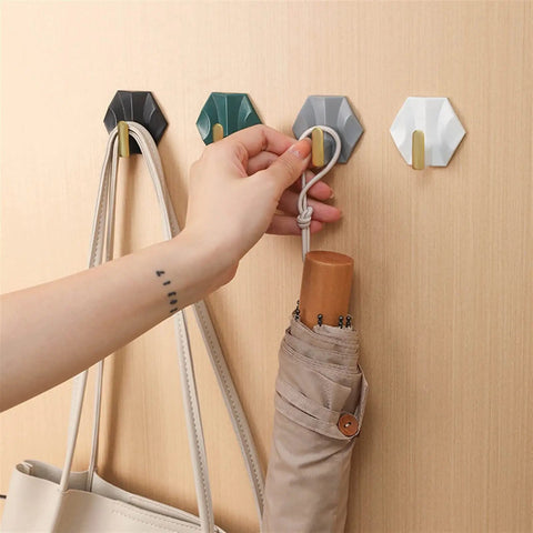 Sleek Adhesive Wall Hooks 4 Pack With Super Tough Grip Tape For Catching Jackets Bags And Keys mounted on wall.