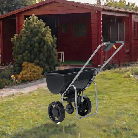 Walk Behind And Tow Behind Broadcast Spreader With A 70 Pound Hopper, 15 Adjustable Flow Control in front of a wooden shed