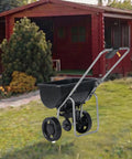 Outdoor Broadcast Lawn Spreader 70 Lbs Capacity Walk Behind Push Spreader with Hopper Grate in garden setting