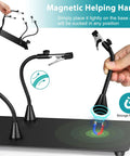 Magnetic helping hand being attached to the base of 10X LED Magnifying Lamp With Light And Stand, showing flexibility and magnetic feature