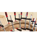 Tradesman Clamp With Four Inch Throat Depth And Twelve Inch Reach In Black And Red Heavy Duty Woodworking Clamp With Patented Serrated Rails For Anti Slip Grip And Buckle Free Lock Ergonomic Wooden Handles Made In USA clamping curved wood panel