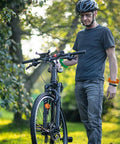 Man wearing 24 Piece Bicycle Theme Motivational Silicone Wristbands Set For Parties BMX Vibes Rubber Wristbands posing with bicycle.